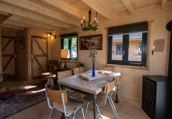 Gezellige woonkamer in de tiny house Jachthut op Camping Vinkenhof in Nederland met houten meubels.