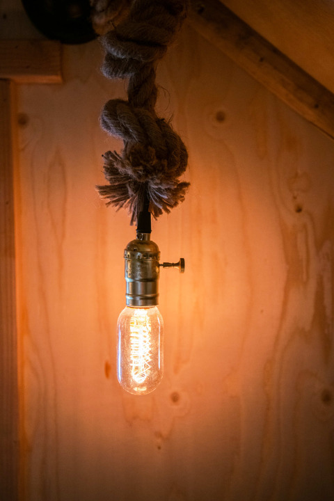 Edison bulb hanging from a rope in Jachthut tiny house at Camping Vinkenhof in the Netherlands.