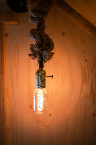 Bombilla estilo Edison colgando de una cuerda en la tiny house Jachthut en Camping Vinkenhof, Países Bajos.