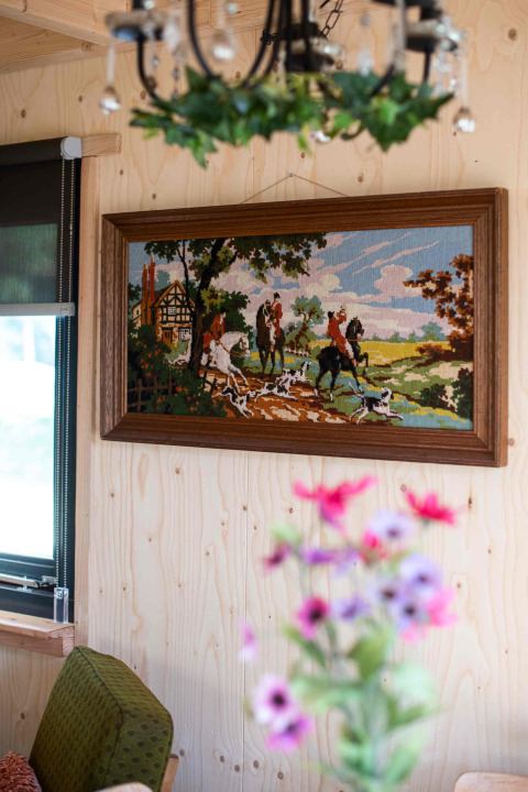 Interno accogliente della tiny house Jachthut al Camping Vinkenhof, Paesi Bassi, con arte murale.