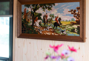 Interno accogliente della tiny house Jachthut al Camping Vinkenhof, Paesi Bassi, con arte murale.