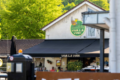 Vista del Café Restaurante Viva La Vink en Camping Vinkenhof, rodeado de árboles en Limburg, Países Bajos.