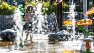 Niño jugando en fuentes de agua en el parque acuático de Camping Vinkenhof, Limburg, Países Bajos.