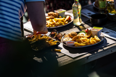 Pranzo all'aperto con patatine e snack al Camping Vinkenhof, parco vacanze in Limburgo, Paesi Bassi.