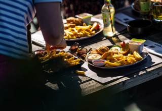 Pranzo all'aperto con patatine e snack al Camping Vinkenhof, parco vacanze in Limburgo, Paesi Bassi.
