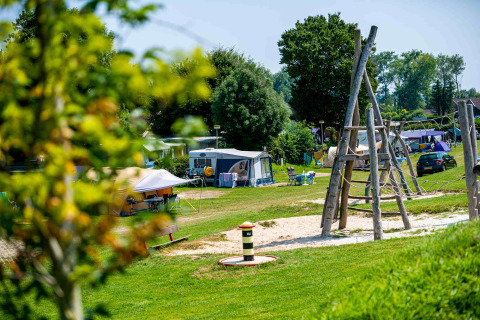Speeltuin en kampeerterrein in vakantiepark Camping Vinkenhof, Limburg, Nederland, tijdens de zomer.