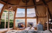 Vista interior del Panorama Dome en Camping Vinkenhof, Países Bajos, con mobiliario moderno y paisaje verde.