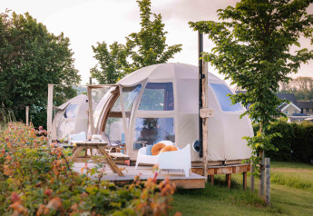 Panorama Dome al Camping Vinkenhof nei Paesi Bassi, tenda glamping moderna con terrazza in legno e natura.