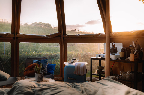 Interior view of the Panorama Dome at Camping Vinkenhof in the Netherlands with cozy setup at sunset.