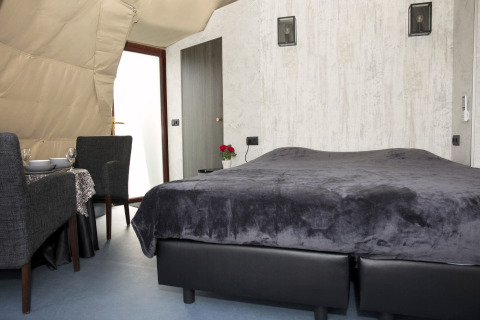 Modern lodge room at Dome at Costa Kabrita, Netherlands, featuring a double bed and dining area.