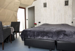 Modern lodge room at Dome at Costa Kabrita, Netherlands, featuring a double bed and dining area.