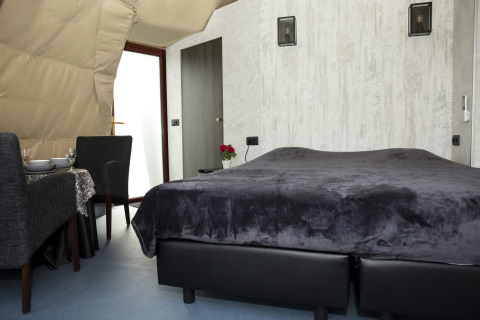 Modernes Schlafzimmer in der Dome-Lodge bei Costa Kabrita, Niederlande, mit Doppelbett und Essbereich.