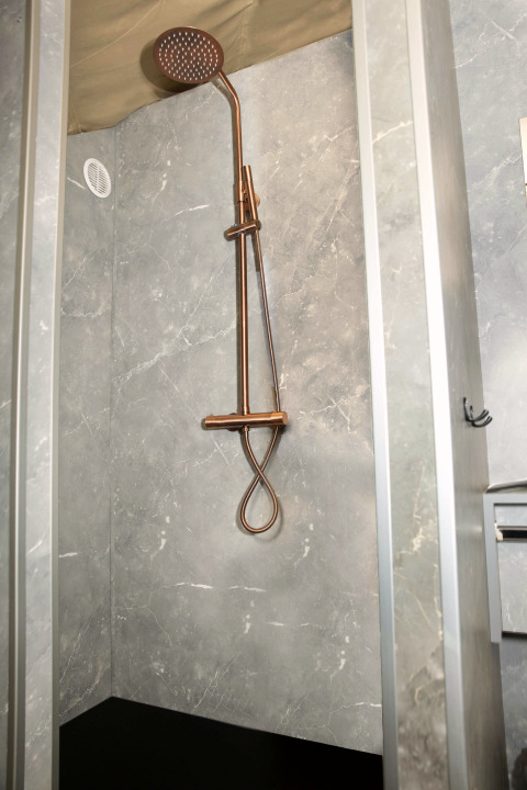 Shower with marble-effect walls in the bathroom at Dome at Costa Kabrita lodge, Netherlands.
