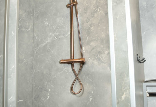 Dusche mit Marmoreffekt-Wänden im Badezimmer der Dome at Costa Kabrita Lodge, Niederlande.