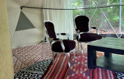 Interior view of the Dome Tent at Buytenplaets Abelen in the Netherlands, featuring elegant chairs and rugs.