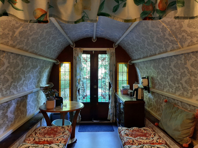 Knus interieur van de Gipsy Wagon tiny house met vintage inrichting bij Buytenplaets Abelen in Nederland.