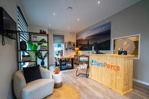 Reception area of a holiday park with modern decor and EuroParcs branding, offering glamping options.