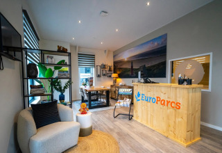 Reception area of a holiday park with modern decor and EuroParcs branding, offering glamping options.