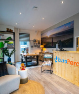 Recepción de un parque vacacional con decoración moderna y logo de EuroParcs, ofrece glamping.