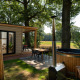 Udendørs areal ved et tiny house med træfacade, sauna og spabad på Holiday Park Mölke, Holland.