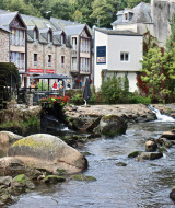 Malersicher Bach mit Wassermühle und historischen Steinhäusern nahe Quimper in der Bretagne, Frankreich.