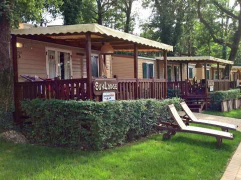 Cabañas SunLodge Aspen con terrazas cubiertas y tumbonas en Altomincio Family Park, Italia, al aire libre.