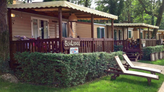 Cabañas SunLodge Aspen con terrazas cubiertas y tumbonas en Altomincio Family Park, Italia, al aire libre.
