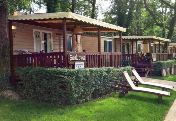 Cabañas SunLodge Aspen con terrazas cubiertas y tumbonas en Altomincio Family Park, Italia, al aire libre.