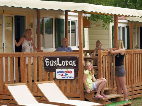 Familia relajándose en la terraza de SunLodge Maple en Altomincio Family Park, Italia.