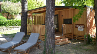SunLodge BigLeaf en hu Norcenni Girasole Village, Italia, rodeado de árboles y con dos tumbonas enfrente.