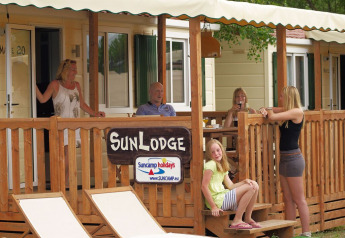 Gezin op het houten terras van SunLodge Maple bij hu Norcenni Girasole Village in Italië geniet samen.