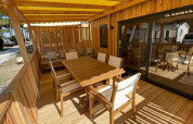 Terraza exterior de madera en SunLodge Babul con mesa, sillas y zona de estar cubierta por toldo.