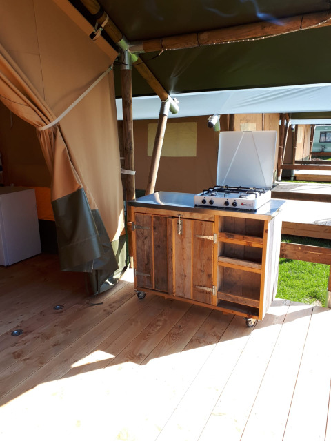 Outdoor-Küche mit Gasherd im Safari-Zelt auf Camping Oos Heem in Belgien, Holzschrank und Regale.