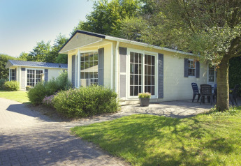 Bungalette basic + hot tub bij Holiday Park Mölke in Nederland, met groen gras, tuin en terras.