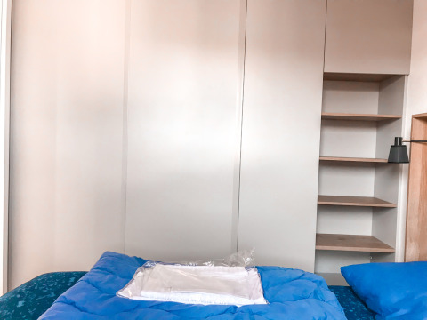 Schlafzimmer in der Forest Lodge im Vakantiepark De Luttenberg, Niederlande, mit blauer Bettwäsche.