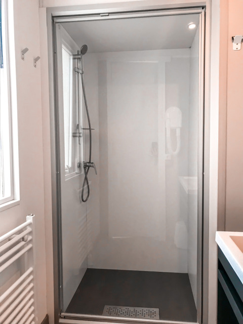Ducha moderna en Forest Lodge en Vakantiepark De Luttenberg, Países Bajos, con puerta de cristal y rociador.