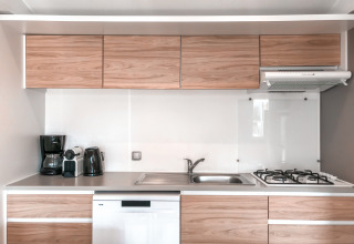 Cocina moderna en Forest Lodge de Vakantiepark De Luttenberg, Países Bajos, con armarios de madera y electrodomésticos.