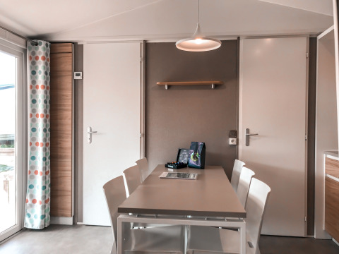 Eettafel met witte stoelen in Forest Lodge van Vakantiepark De Luttenberg, Nederland, modern interieur.