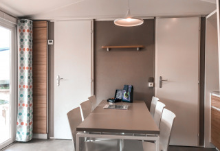 Eettafel met witte stoelen in Forest Lodge van Vakantiepark De Luttenberg, Nederland, modern interieur.