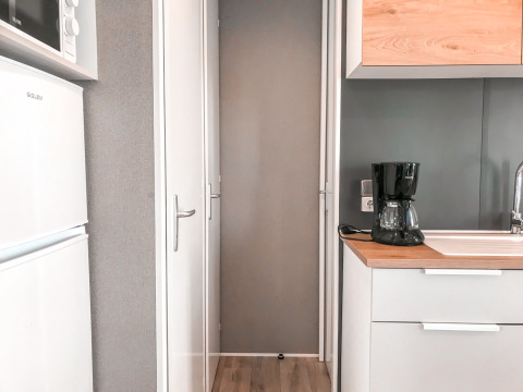 Moderne kitchenette met koffieapparaat, spoelbak, koelkast en microgolf in Forest Lodge bij Vakantiepark De Luttenberg.