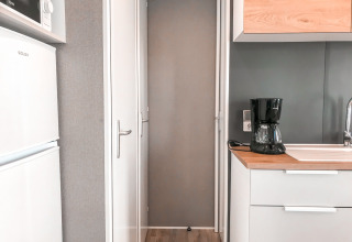 Moderne kitchenette met koffieapparaat, spoelbak, koelkast en microgolf in Forest Lodge bij Vakantiepark De Luttenberg.