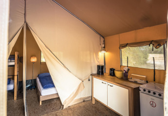 Indvendigt billede af en safari-telt lodge på Vakantiepark De Luttenberg med soveområde og tekøkken.