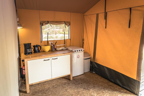 Foto del interior de una cocina de tienda Safari con estufa, cafetera y fregadero en Vakantiepark De Luttenberg.