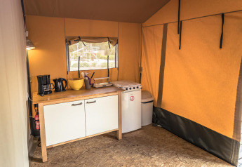 Indvendig billede af et Safari-teltkøkken med komfur, kaffemaskine og vask på Vakantiepark De Luttenberg.