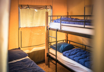 Indvendigt billede af Safari-teltet med køjesenge og soveposer på Vakantiepark De Luttenberg, Holland.