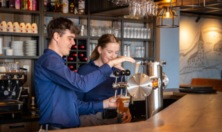 Zwei Barkeeper zapfen Bier an der Bar von Camping Waddenzee, einem Ferienpark in Nordholland.