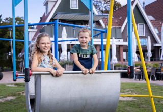 To børn leger på legepladsen ved Camping Waddenzee feriepark i Nordholland, Holland, en solrig dag.