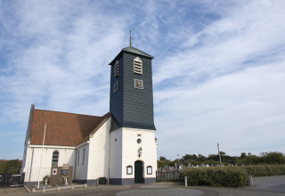 Chiesa con pareti bianche e torre scura vicino a Westerland, Olanda Settentrionale, Paesi Bassi.