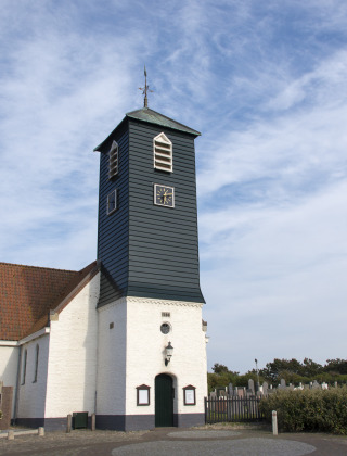 Iglesia de paredes blancas y torre oscura cerca de Westerland, en la provincia de Holanda Septentrional, Países Bajos.