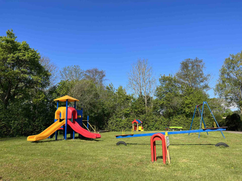 Parco giochi al Vakantiepark de Zeeuwse Parel in Zelanda, Paesi Bassi, con scivolo, altalene e altalena a bilico.